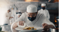 A chef holding a plate of food