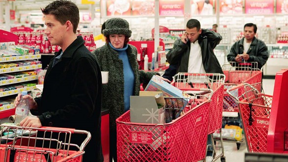 A grocery store checkout line with four individuals queued up, spaced apart by approximately a cart's length, except for the first two individuals who are closer together. The third person in line is engaged in a phone call, and no one is wearing a mask. A heat map overlays areas of perceived risk from group 4, primarily focusing on the vicinity of the closer individuals and the individual on the phone.